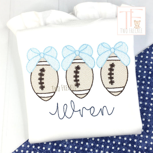 a white shirt with three footballs on it